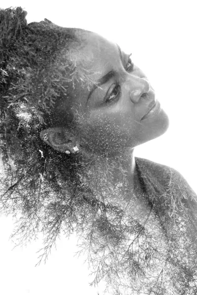 A black and white portrait of an African American woman combined with foliage in a double exposure technique. — Stock Photo, Image