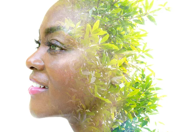 A portrait of a pretty woman dissolving into an image of foliage. Double exposure. — Stock Photo, Image