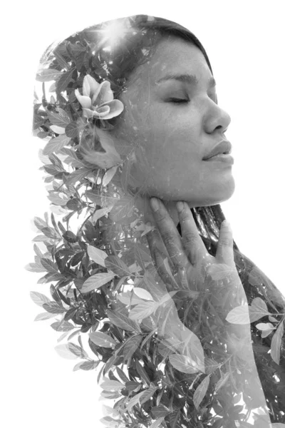 Um retrato preto e branco de uma mulher com uma flor no cabelo combinada com folhagem. — Fotografia de Stock