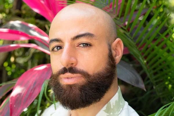 Closeup portrait of a bearded man against tropical foliage — Stockfoto