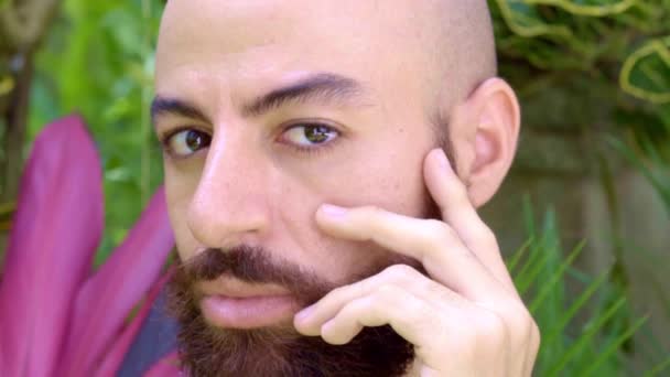 A portrait of a bearded gay man with a hand at his face — Stockvideo