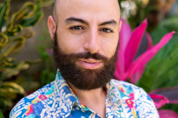 Glimlachende man met baard tegen tropische achtergrond — Stockfoto
