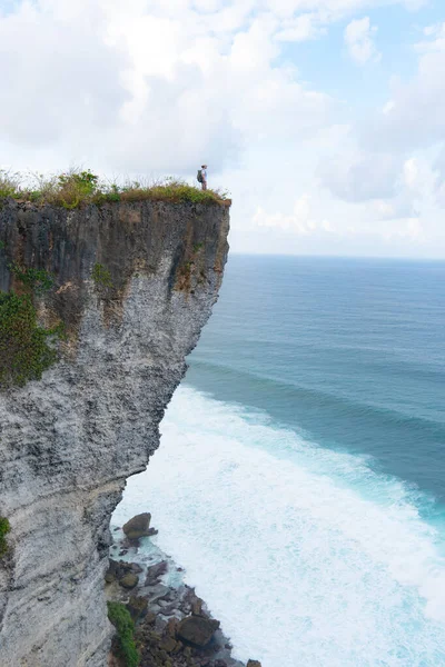 Un om stând pe o stâncă uitându-se la ocean — Fotografie, imagine de stoc