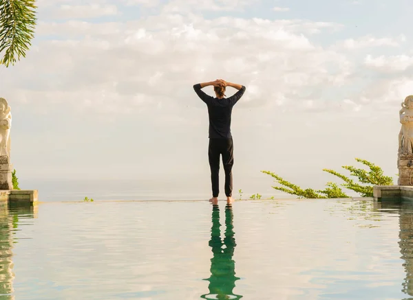 Ein Mann steht am Rande des Infinity Pools — Stockfoto