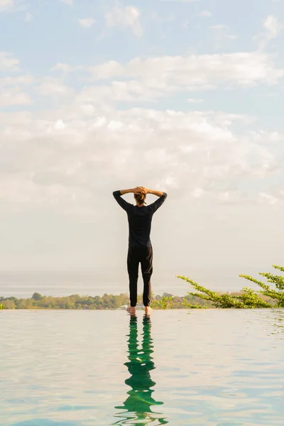 Een man die aan de rand van een oneindig zwembad staat — Stockfoto