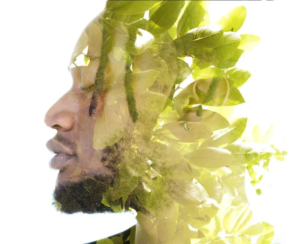Un ritratto a doppia esposizione di un uomo combinato con un'immagine di foglie verdi. — Foto Stock