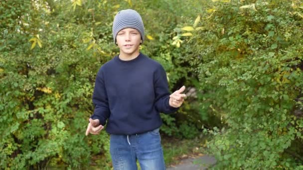 Boy speaks in front of video camera for his blog channel in autumn outdoors. Little influencer — Stock Video