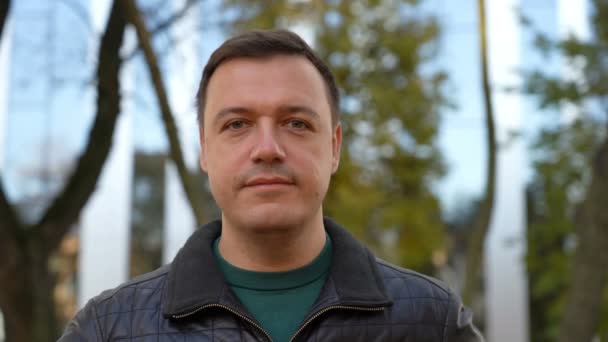 Businessman standing outdoors, looking at camera and shaking head for agreement — Video Stock