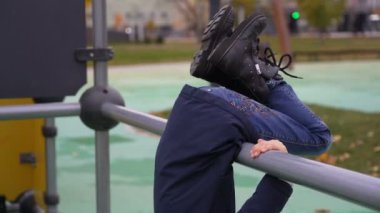 Mutlu kız direğin üzerinde dönüyor. Sonbaharda çocuk parkında eğleniyor.
