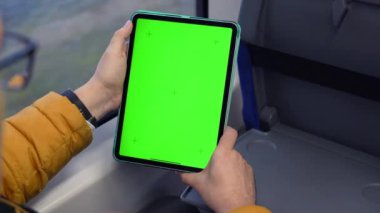 İnsan izleme tabletinin yeşil ekranlı arka planı ve trende çevrimiçi gezinme