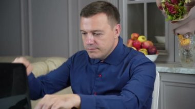 Anxious man at work as employee with laptop and gripping hand expander antistress suction cup pop it