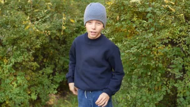 Kid blogger boy speaks in front of video camera for his blog channel in autumn outdoors — Stock video