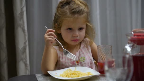 Little girl eats pasta at lunch. The child choked on pasta and regurgitates them back into the plate — Stock Video