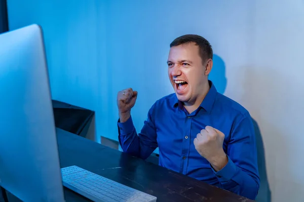 Happy person looks at computer monitor and celebrates his success, feeling extremely lucky, surprised. Excited businessman received good news — Stock Photo, Image