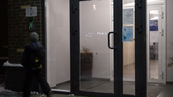 Code ouvert d'entrée de jeune garçon sur l'intercome et entrez dans l'immeuble d'appartements en hiver — Video
