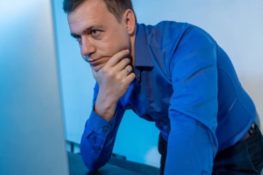 Milenyum adamı ofiste durmuş iş projesini düşünüyor. Yeni açılan iş yerinde mavi gömlekli genç işadamı, masaüstü bilgisayarı üzerinde çalışıyor. Evdeki masada çalışan bir adam.