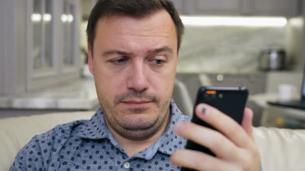Retrato del gerente encogiéndose y mirando la pantalla del teléfono, broma mala o contenido inapropiado — Vídeo de stock