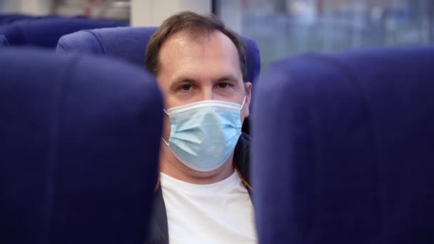 Pria kulit putih bertopeng di gerbong kereta bawah tanah dan melihat ke kamera selama pandemi coronavirus — Stok Video