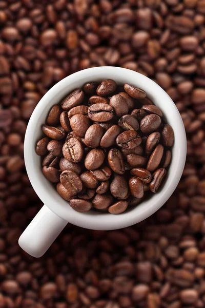 Filiżanka kawy na tle fasoli — Zdjęcie stockowe
