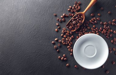 Fasulyeli çay tabağı ve siyah desenli arka planda ahşap kepçe.