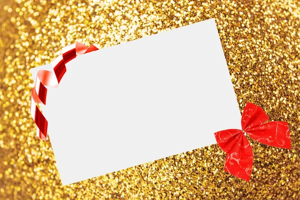 Kerst vel papier met strik en linten op gele onscherpe achtergrond — Stockfoto