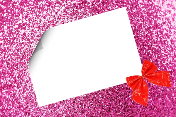 Vánoční list papíru s lukem a stuhy na růžové rozostřeného pozadí — Stock fotografie