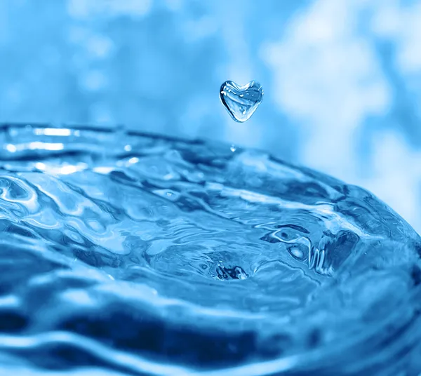 Spruzzi d'acqua con goccia nella forma di cuore — Foto Stock