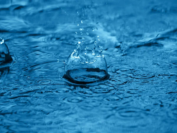 Splash de água na superfície azul — Fotografia de Stock