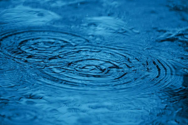 Splash de água na superfície azul — Fotografia de Stock