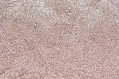 Dokulu arka plan. Dekoratif alçı duvarlar, dış cephe dekorasyonu. Bej rengi, pembe.