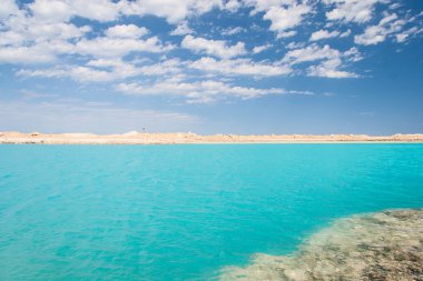 Kum ve kayaların arasındaki Mavi Göl