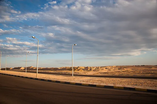 Empty asphalt road with cloudy sky and sunlight — Stock Photo, Image