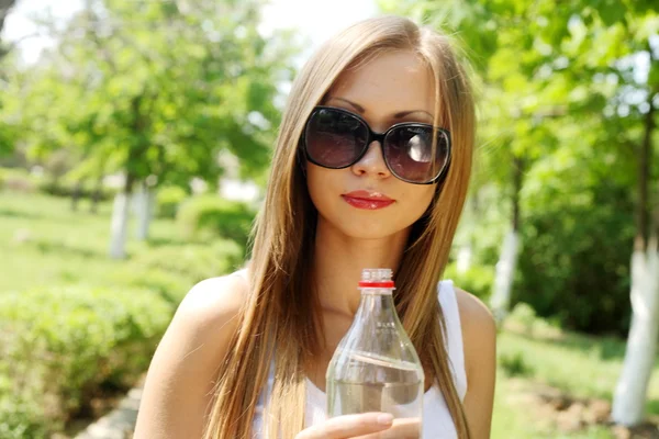 Bella donna che beve acqua al parco verde estivo . — Foto Stock