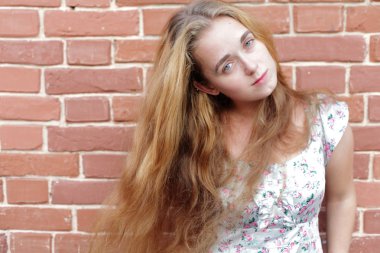 sarışın kadın ve tuğla duvar