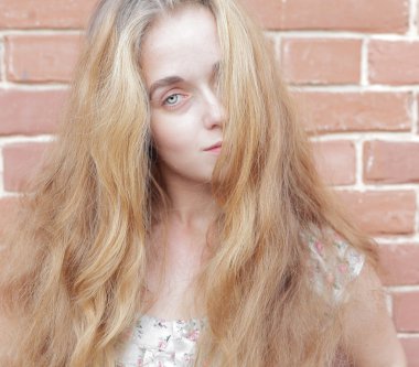 sarışın kadın ve tuğla duvar