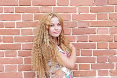 sarışın kadın ve tuğla duvar