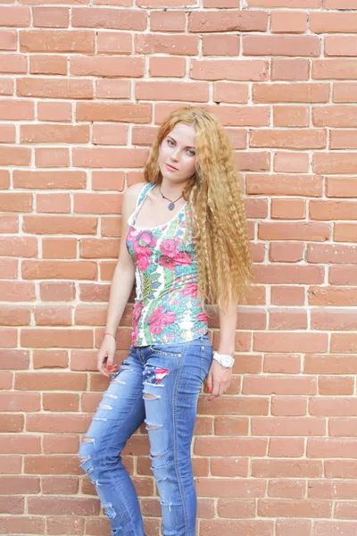 Blond kobieta i ceglane ściany — Zdjęcie stockowe