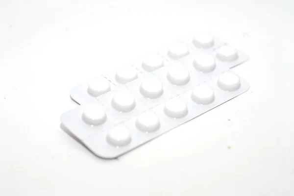 Fehér bőrön izolált tabletták — Stock Fotó