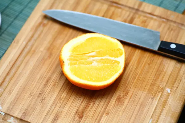 Half of orange cut with knife — Stock Photo, Image