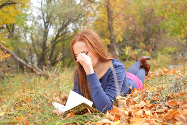 Молода, красива дівчина тримає відкриту книгу, читати — стокове фото