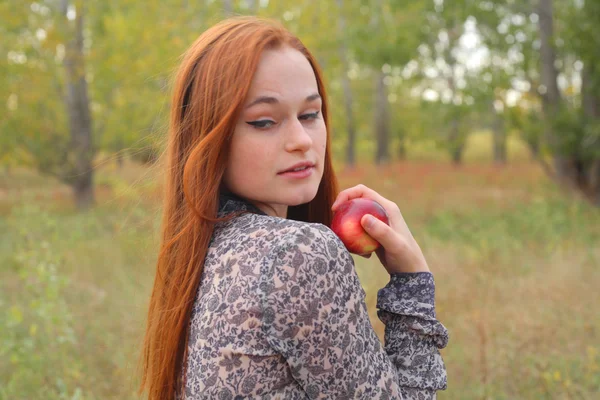 Kırmızı elma elinde tutan genç kadın portresi — Stok fotoğraf
