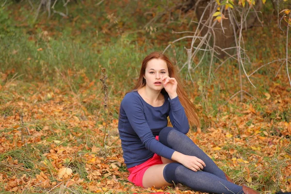 Romantikus lány ül, az őszi levelek — Stock Fotó