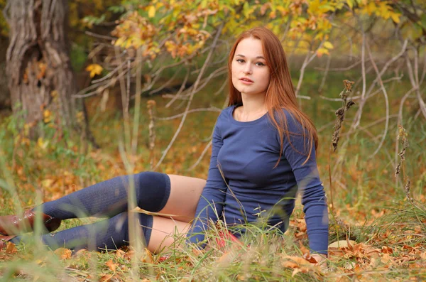 Romantische meisje zit in de herfst bladeren — Stockfoto