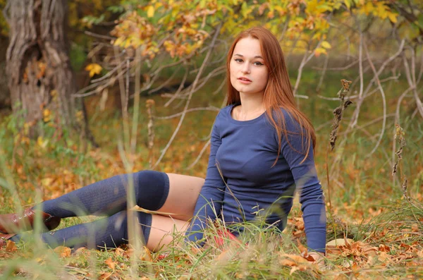 Romantic girl sitting in autumn leaves — Stock Photo, Image