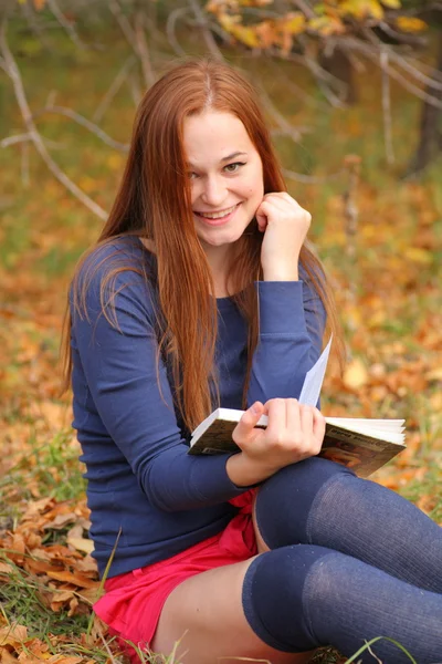 Όμορφη κοπέλα με κόκκινα μαλλιά, διαβάζοντας ένα βιβλίο — Φωτογραφία Αρχείου