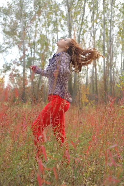 Beautiful woman standing in a park in autumn — Stock Photo, Image