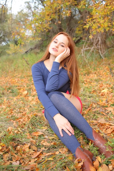 Portrait of a beautiful red-haired woman sitting on the grass — Stock Photo, Image