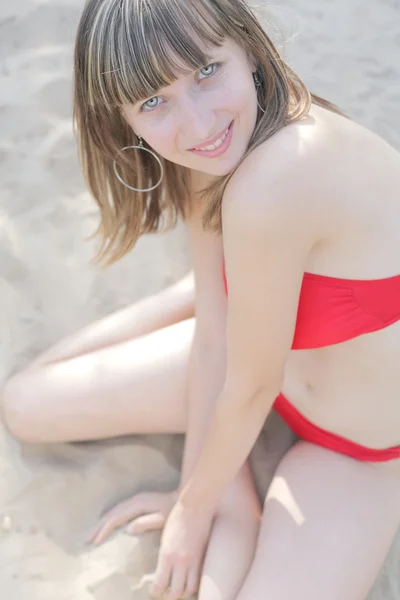 Schöne junge Frau im Bikini sitzend — Stockfoto