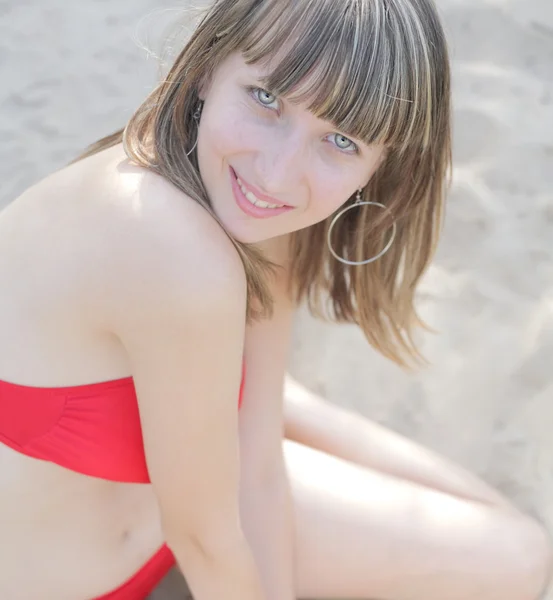 Schöne junge Frau im Bikini sitzend — Stockfoto