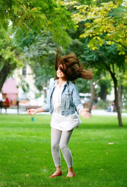 Giovane donna jamping su un'erba — Foto Stock